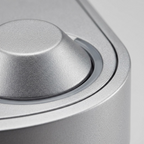 A macro photo focuses on the texture of the metallic finish and precision of the single button and indicator.