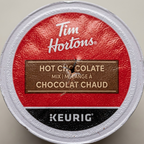 Macro detail focuses on the punctured foil lid texture, revealing a distinct needle entry mark.