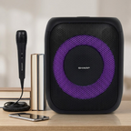 Sharp PS-914 party speaker with mic and stacked books on a wooden desk.