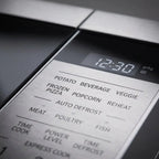 Extreme close-up of the stainless steel control panel, highlighting precise text labels and button texture.