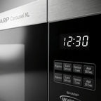 A close-up photograph of the SHARP SMC2264KSC microwave control panel showing the digital display and key buttons.